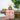 Pomegranate Garden Sunset collection table runner shown with tableware and floral accessory