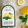 Packaged lemon basil fettuccine with lemons and basil leaves on a textured surface
