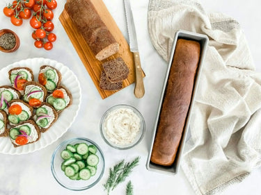 Assorted bread slices with spreads and vegetables on a white surface