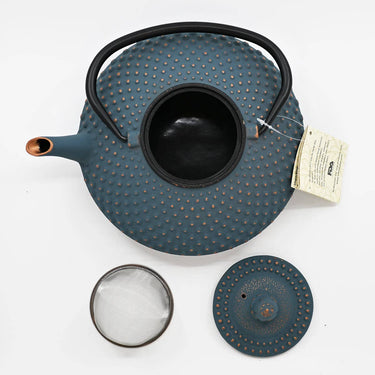 Blue textured teapot with accessories on a white background