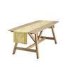 Wooden table with a yellow patterned table runner on a white background