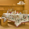 Dining room with a table set for a meal, featuring a floral tablecloth and decorative items.