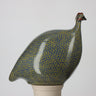 Ceramic bird sculpture with a blue and green pattern on a white background