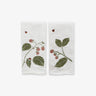 Two white towels with berry and leaf designs on a white background