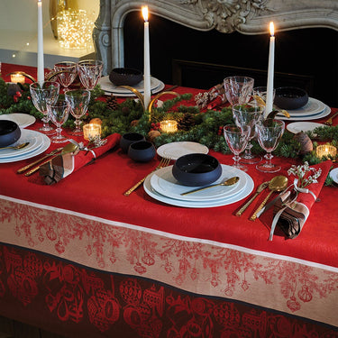 Red and brown holiday tablecloth with white plates and black bowls