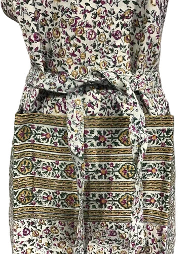 Floral and geometric patterned dress with a belt on a plain background